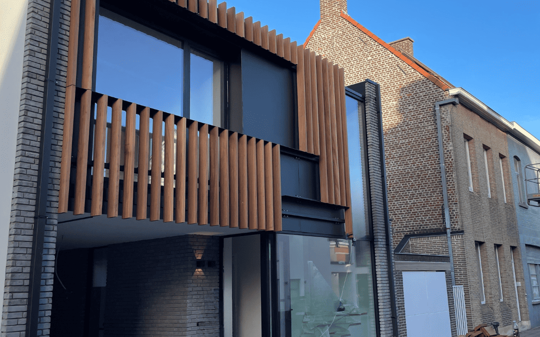 Gevelbekleding uit aluminium afgewerkt met hardhouten lamellen.
